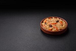Delicious fresh pilaf with rice, carrots, meat, onions, spices and berries photo