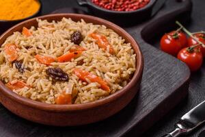 Delicious fresh pilaf with rice, carrots, meat, onions, spices and berries photo