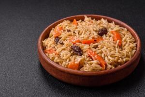 Delicious fresh pilaf with rice, carrots, meat, onions, spices and berries photo