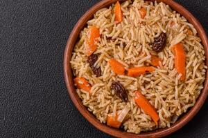 Delicious fresh pilaf with rice, carrots, meat, onions, spices and berries photo