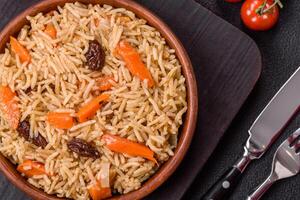 Delicious fresh pilaf with rice, carrots, meat, onions, spices and berries photo