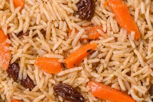 Delicious fresh pilaf with rice, carrots, meat, onions, spices and berries photo