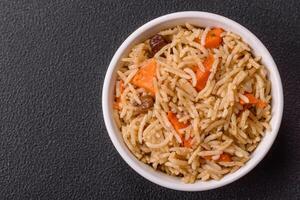 Delicious fresh pilaf with rice, carrots, meat, onions, spices and berries photo