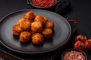 Delicious fried potato balls or croquettes with salt, spices and herbs photo
