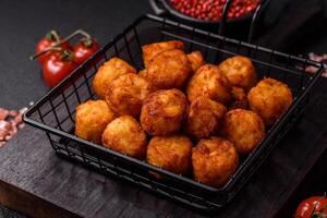 Delicious fried potato balls or croquettes with salt, spices and herbs photo