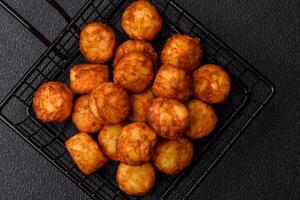 Delicious fried potato balls or croquettes with salt, spices and herbs photo