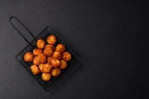 Delicious fried potato balls or croquettes with salt, spices and herbs photo