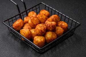 Delicious fried potato balls or croquettes with salt, spices and herbs photo