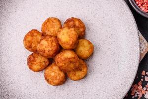 Delicious fried potato balls or croquettes with salt, spices and herbs photo