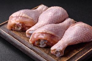 Raw chicken legs with salt, spices and herbs photo