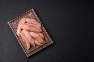 Raw chicken fillet cut into strips with spices and herbs photo