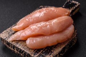 Raw chicken fillet cut into strips with spices and herbs photo