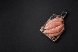 Raw chicken fillet cut into strips with spices and herbs photo