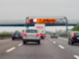 A blurry image of a busy highway with cars and a truck photo