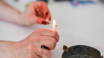 unrecognizable person prepare smoke hashish tobacco cigarette joint personal health relax use at home photo