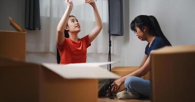 Portrait of Two Asian women are helping to assemble a floor lamp in the living room in new home. Moving to a new home concept photo