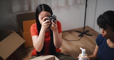High angle view, Two siblings happily sit on the floor talking as they unpack belongings from boxes to decorate a room in new home. Moving to a new home concept photo