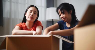 Portrait of Two siblings happily sit on the floor talking as they unpack belongings from boxes to decorate a room in new home. Moving to a new home concept photo