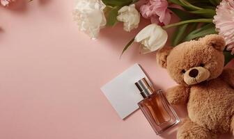 A teddy bear and perfume on a pink background photo