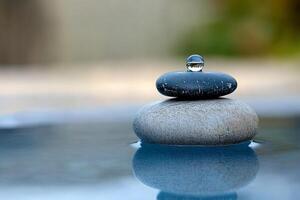 A stone and water drop sitting on top of each other photo