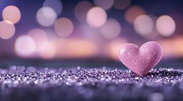 A sparkling pink heart on a glittery surface with a bokeh background. photo