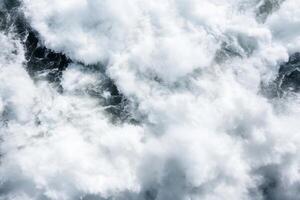 Aerial view of turbulent ocean waves and frothy white surf. photo