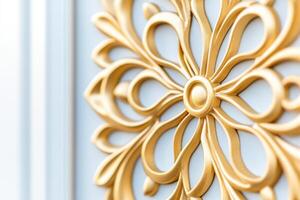 Gilded mirror with intricate designs reflecting soft natural light against a white wall in an elegant setting photo