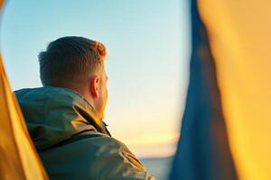 Soldier enjoys warm connection with loved ones during deployment inside tent while calling at sunset photo