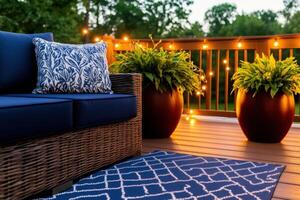 Elegant patio with navy cushions, planters, and warm string lights beneath an evening sky photo