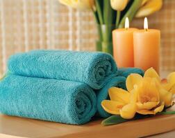 Relaxing spa setting with teal towels, candles, and vibrant flowers creating a tranquil atmosphere for wellness and rejuvenation photo