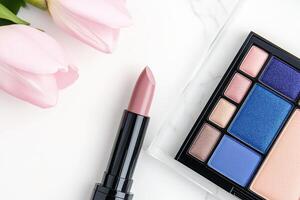Essentials for a flawless makeup look featuring vivid colors and a touch of elegance on a glass surface photo