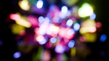 Soft colorful bokeh lights rotating on black in a seamless loop. video