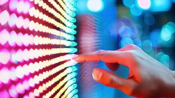 A close-up of a hand interacting with colorful LED lights, showcasing modern technology and vibrant illumination. video