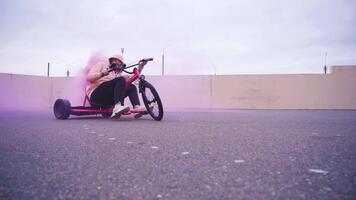 An exciting Dynamic Trike Ride featuring a beautiful pink smoke effect in a vibrant urban setting video