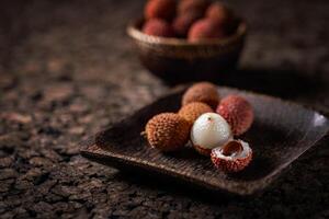 Fresh lychees are served on a wooden tray photo