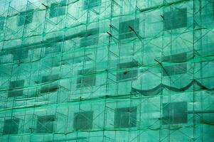 Building structure with green netting shade and scaffolding photo