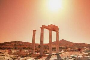 The sun is shining on a large column in the desert photo