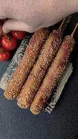 Lula kebab meat fried on a fire in breading with salt, spices and herbs on a dark concrete background video