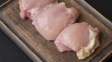Fresh raw chicken thigh fillets with salt, spices and herbs on a dark concrete background video