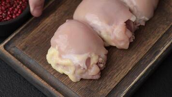 Fresh raw chicken thigh fillets with salt, spices and herbs on a dark concrete background video