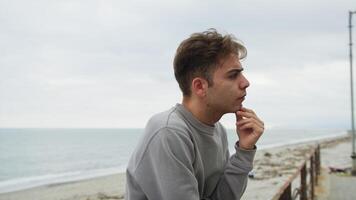 Boy With Pensive Expression On His Face Looks Toward The Horizon On The Beach video