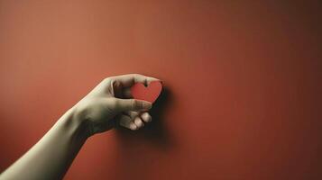 Hand gently holding red paper heart image copy space. Romantic theme, heartfelt message banner background. Tender emotion. Love, compassion and kindness concept photography copyspace photo