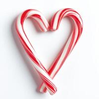 Candy canes forming a heart shape on a white background photo