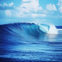 Stunning ocean wave curling under a vibrant blue sky photo
