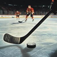 Close-up of hockey stick and puck on ice during a game photo