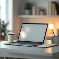 Minimalist workspace featuring laptop, coffee cup, and stationery photo