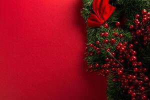 Close-Up of Red Color Ornaments on Evergreen Pine with Red Wall Background photo