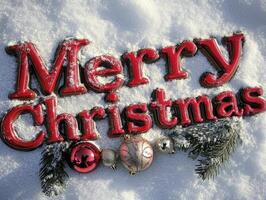 The word Merry Christmas written in red on white snow, with Christmas decorations around it. photo