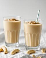 Two glasses of peanut butter smoothie with a straw photo