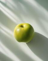 A green apple on a white surface photo